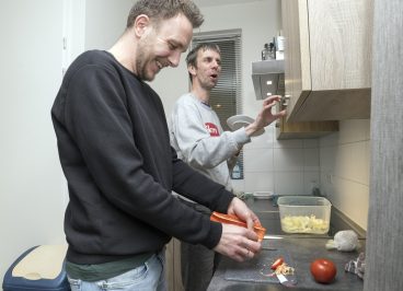 begeleider en client bereiden eten voor in de keuken