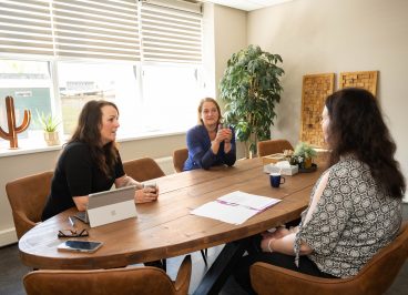 drie vrouwen aan tafel in gesprek