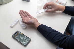 Bewoner ontvangt medicatie van begeleider